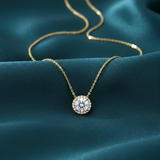 Gold diamond pendant necklace on teal silk background