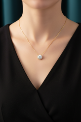 Model wearing gold diamond halo pendant necklace