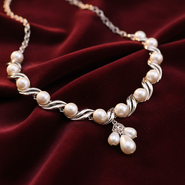 Silver pearl strand necklace on deep burgundy velvet background